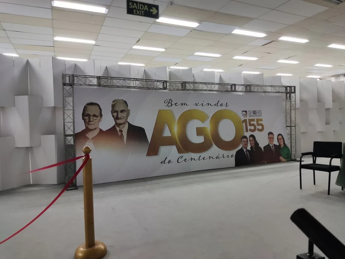 Backdrop com a marca do evento montado ao fundo de um palco