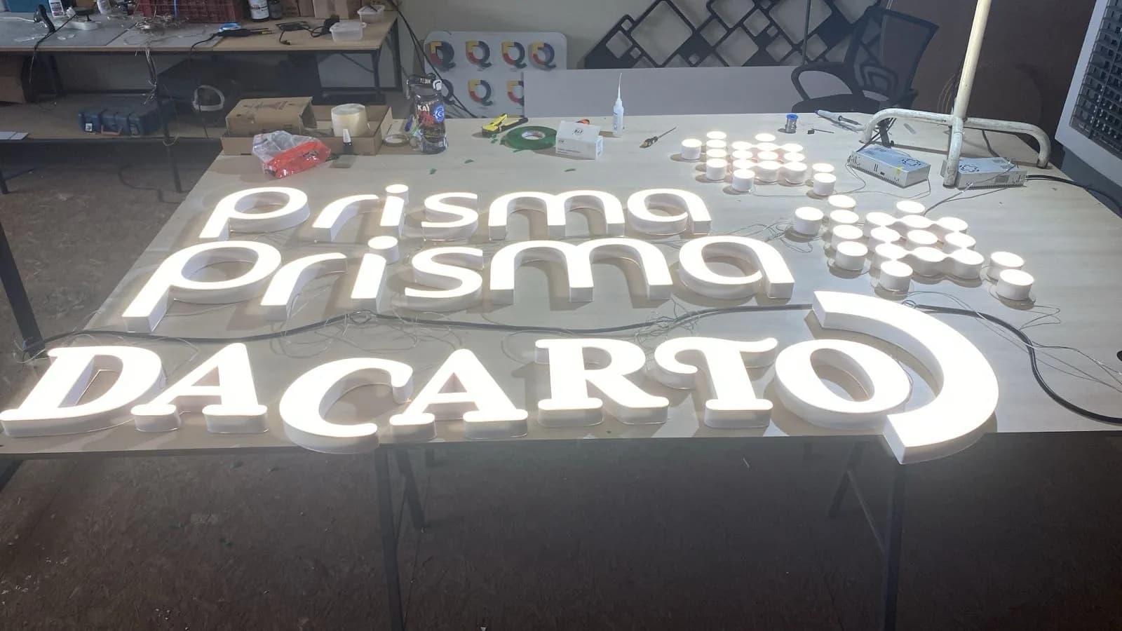 Letras caixa iluminadas instaladas na fachada de uma loja à noite